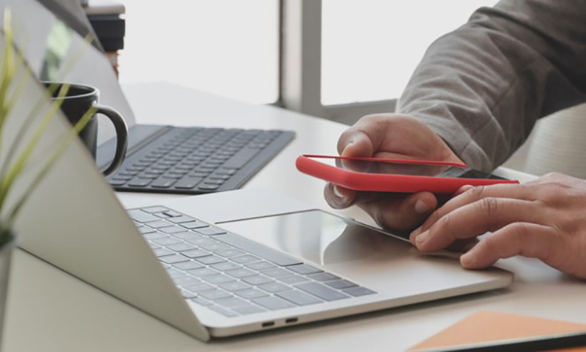 Man using both a laptop and mobile phone