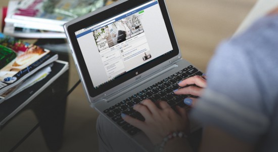 A picture of a man using Facebook, on a laptop 