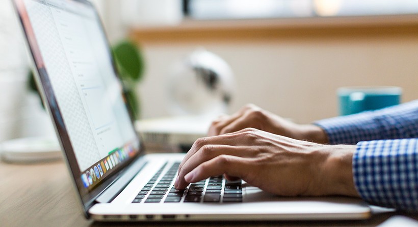 A person typing on a laptop. 