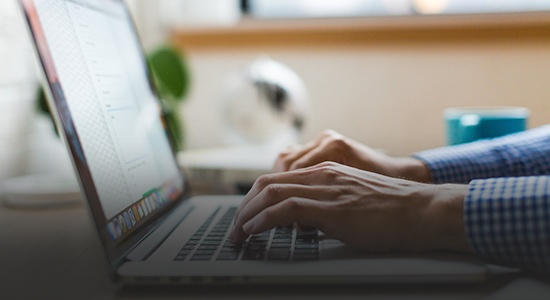 A person typing on a laptop. 