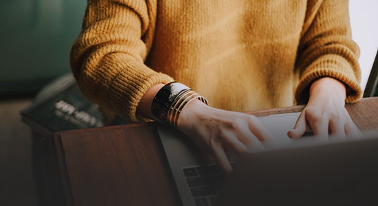 Lady typing on her laptop - blog writer word count - faded