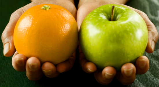 Hands holding an orange and an apple