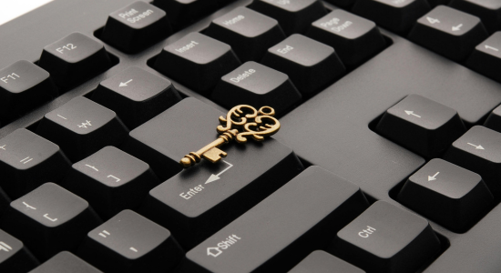 A door key resting on the Enter key of a black keyboard.