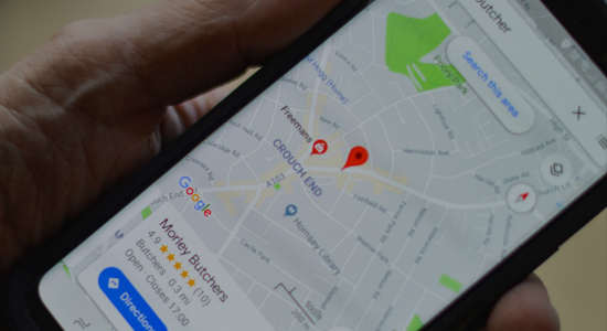 A smartphone on Google Maps showing a map pin.