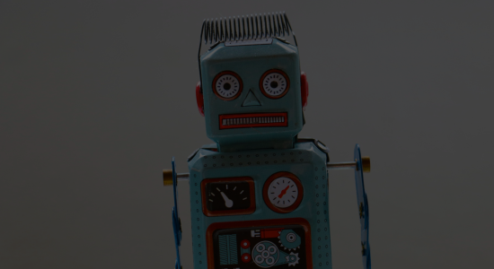 A tin robot toy against a grey background.